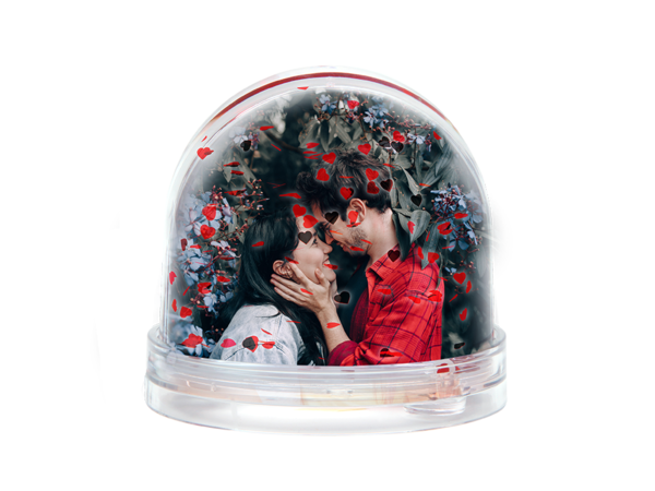 Glitzerkugel mit roten Herzen und Herzflocken zeigt ein Paar, das sich liebevoll ins Gesicht fasst und innig anschaut.