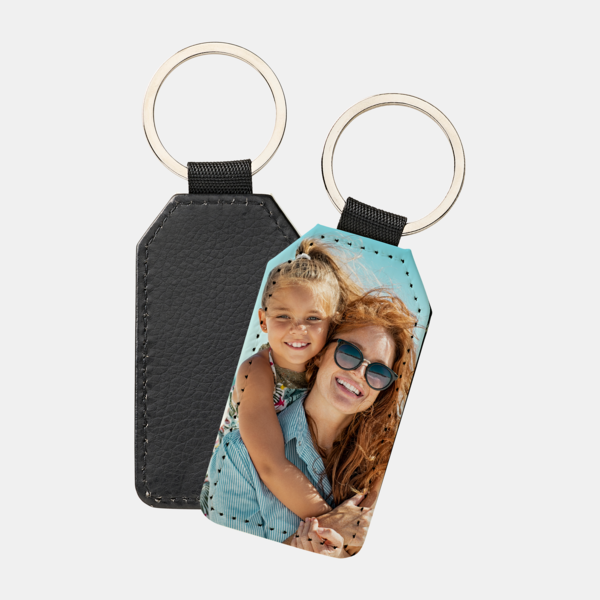 Personalisierter Schlüsselanhänger in Flaggenform mit Foto von zwei lachenden Personen im Sonnenlicht.