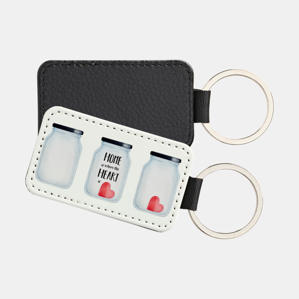 Der Schlüsselanhänger Rechteckig zeigt drei Gläser, geschmückt mit Herzen und dem Text „Home is where the heart is“.