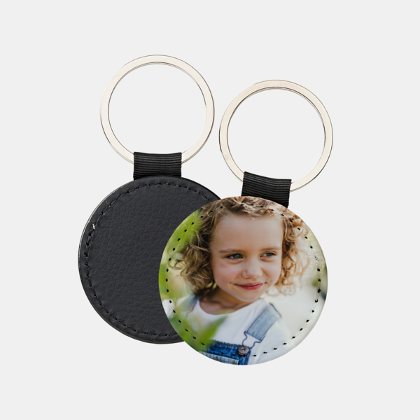 Foto-Schlüsselanhänger in Rundform mit silbernem Ring, zeigt ein Kind mit lockigem Haar und hellem Hintergrund.